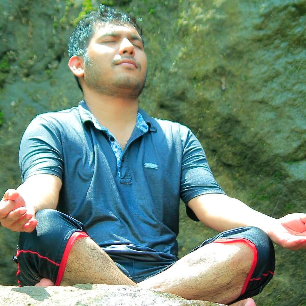 Faisal Tusher meditating on a rock